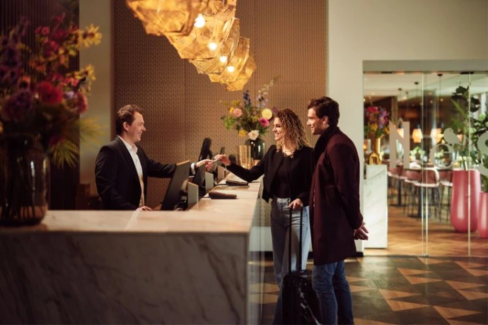 Chef de réception d'hôtel accueillant des clients